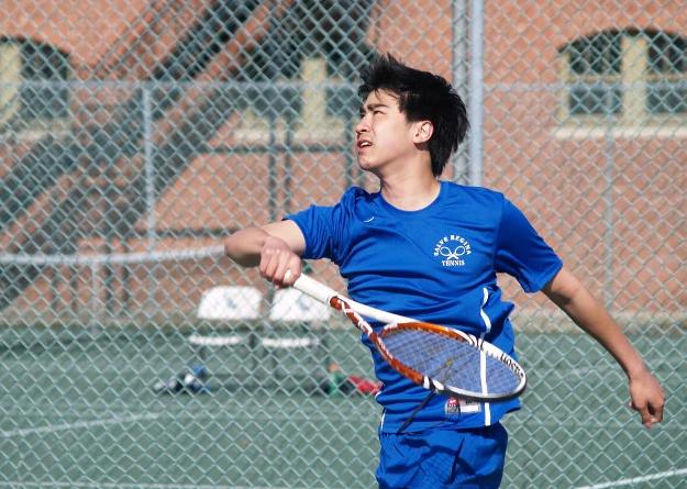 Khoa Nguyen finishes a swinging volley during his match at second singles; the second-year player won his second match of the season. (Photo by Khari Halliburton)