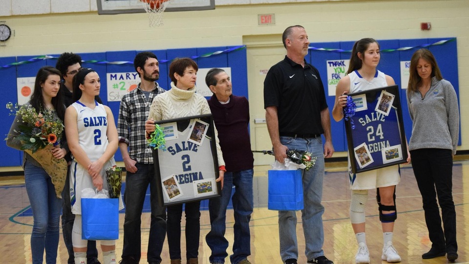 Mary Eden and Ally Esielionis gather with family while head coach Cori Hughes (off camera) gives a testimony on behalf of her seniors. (Photo by Hannah Filiault)