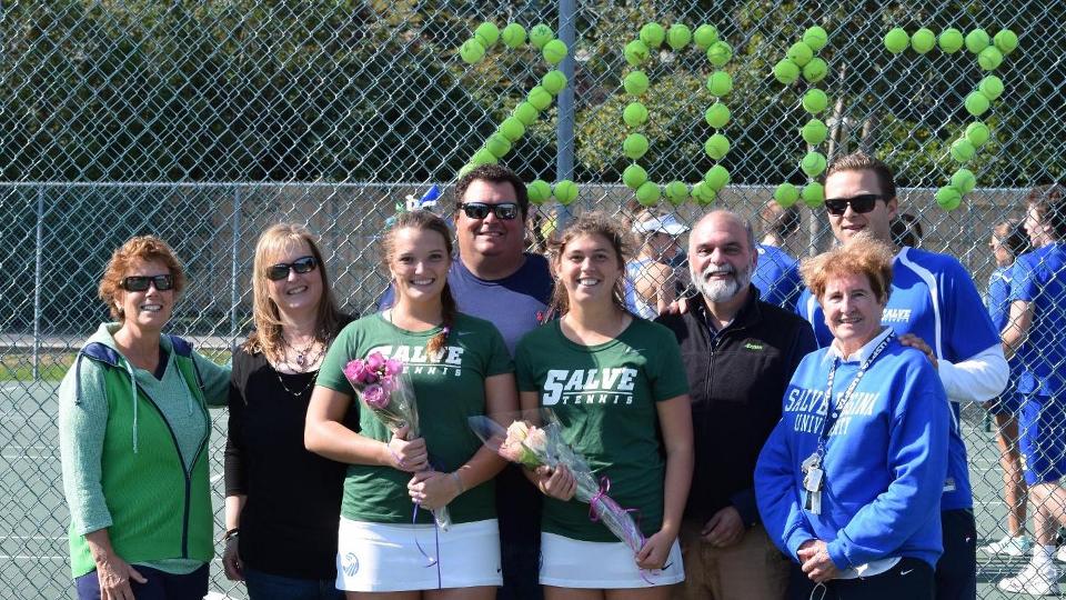 Salve Regina director of athletics Jody Mooradian (left) joins Seahawk senior players Taylor Amendola and Emma Gruber with coaching staff and families. (Photo by Ed Habershaw)