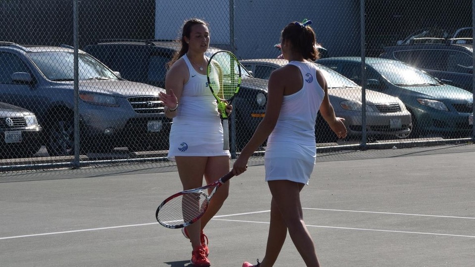 Laura Krick and Erin Stangel congratulate each other on a point won at first doubles. (Photo by Jacob Fluegel)