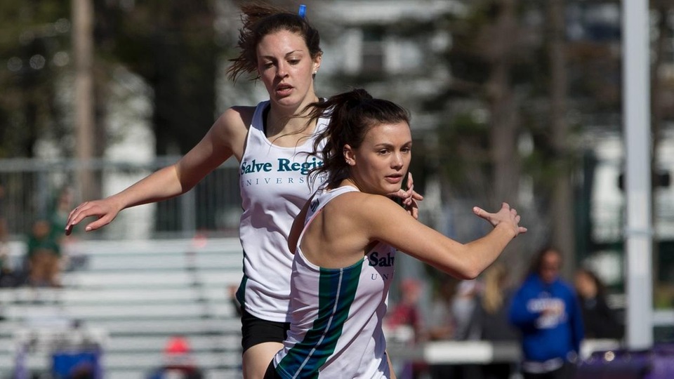 Megan Jenkins exchanges baton with Natalie Kopiec in relay. (Photo by Jen McGuinness)