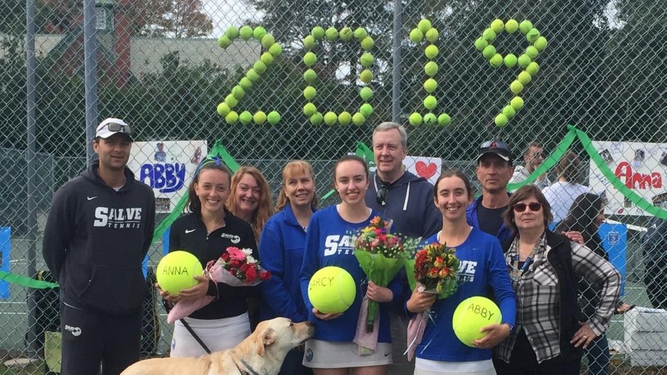 Salve Regina seniors Anna Godshalk, Darcy Carlin, and Abigail Burke are joined by family and head coach Pete Torgrimson during pre-match ceremonies on Sunday. (Photo by Ed Habershaw)